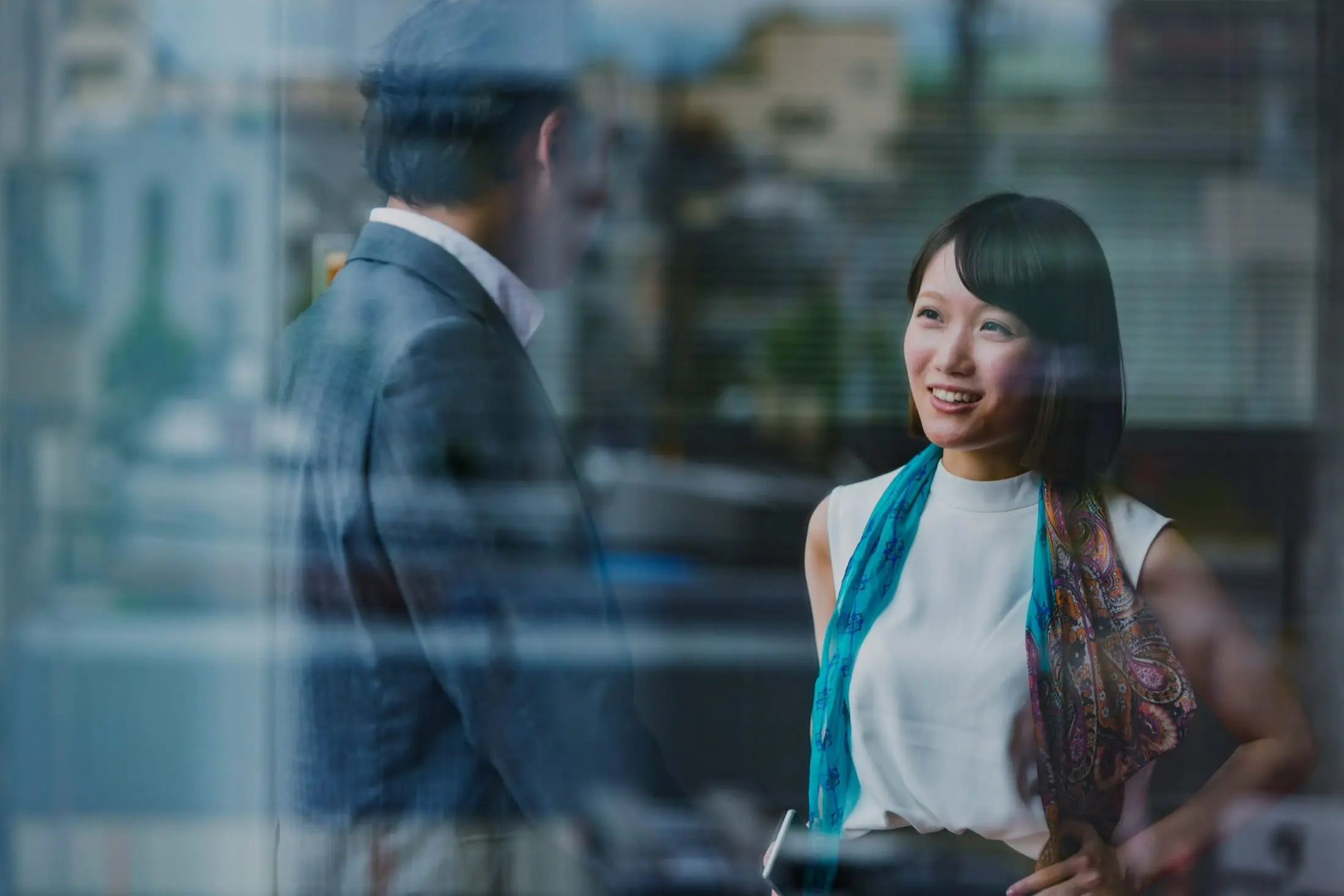 Business Man and Woman Meeting Viewed Through Office Window 