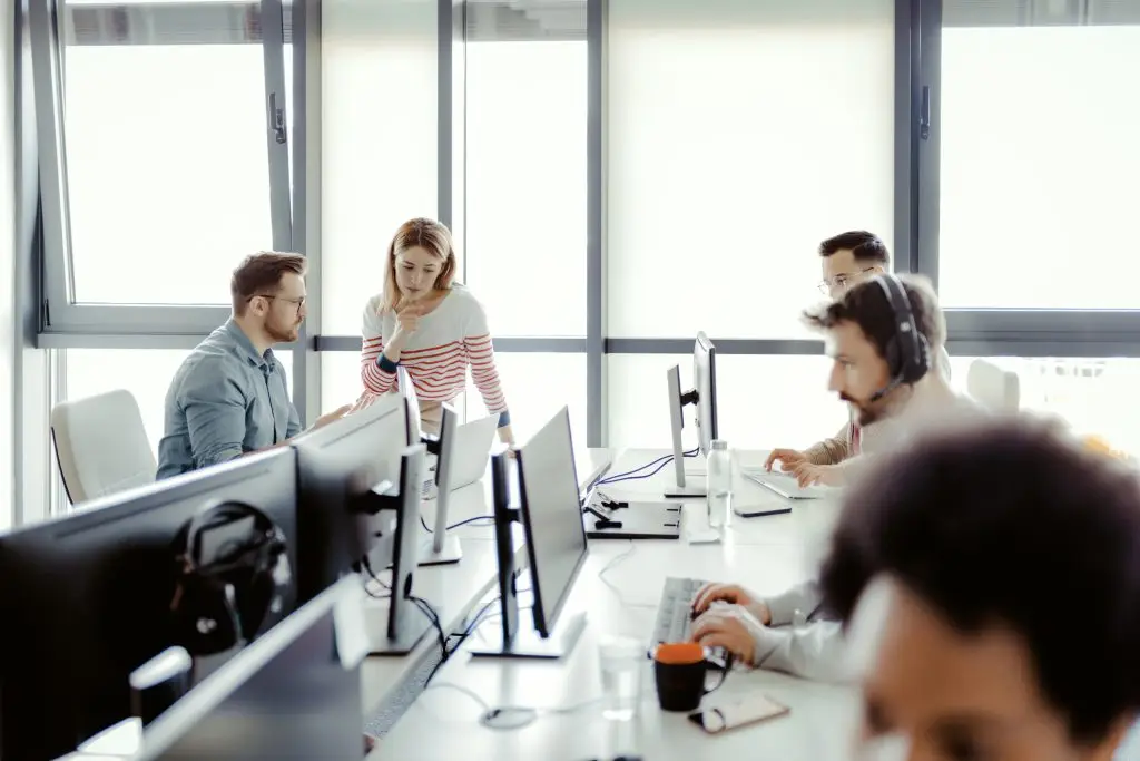 A group of people working on computers in an office.