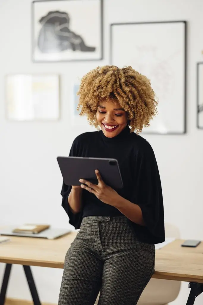 Une jeune femme afro-américaine utilisant une tablette électronique dans son bureau.