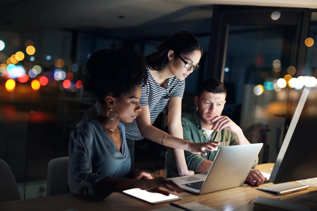 A group of people looking at a laptop.