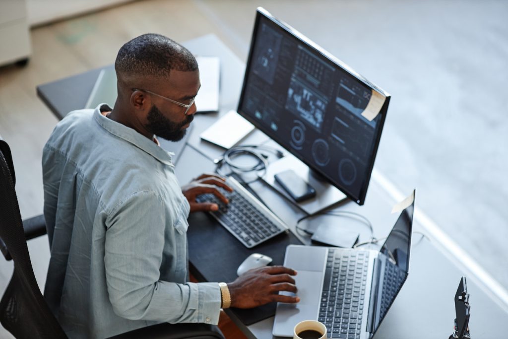 A man sitting at a desk using a computer.