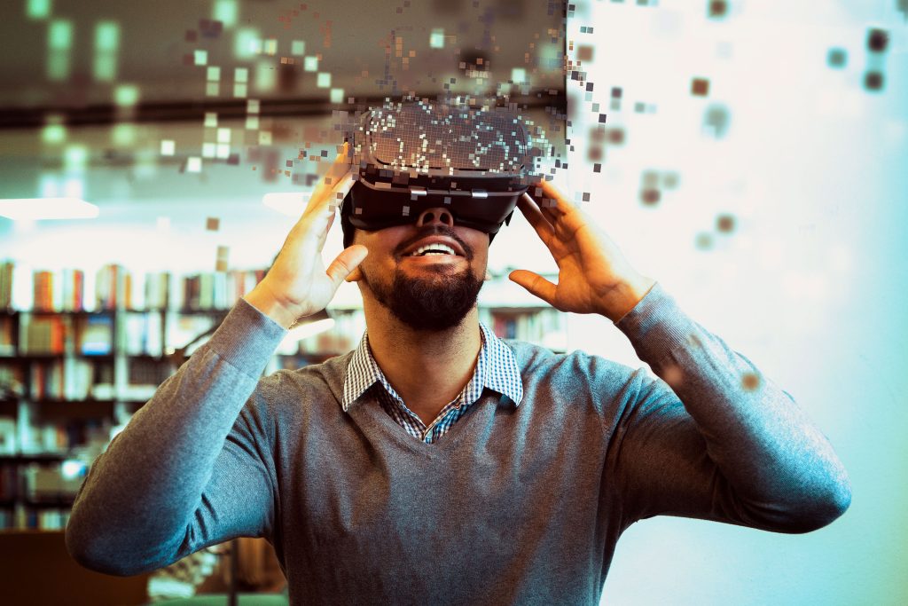 Un homme portant un casque de réalité virtuelle dans une bibliothèque.