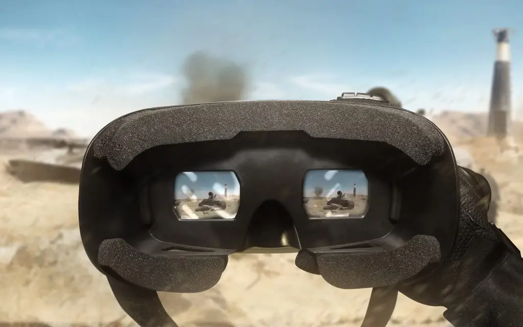 A person holding a vr headset in front of a desert.