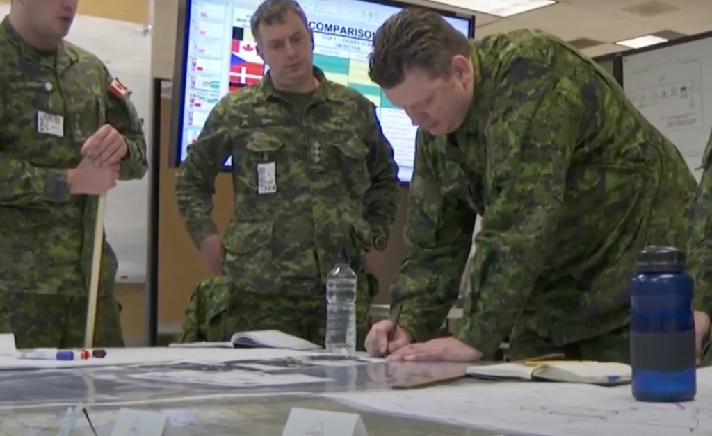 A group of military men are working on a map.