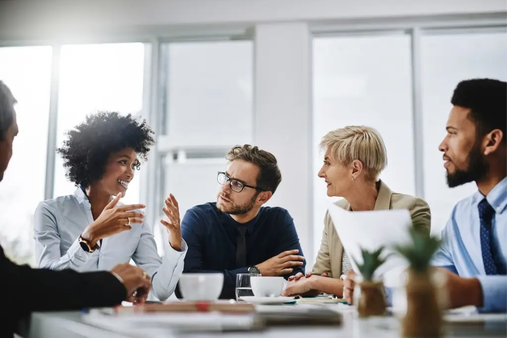 A group of business people talking at a meeting.