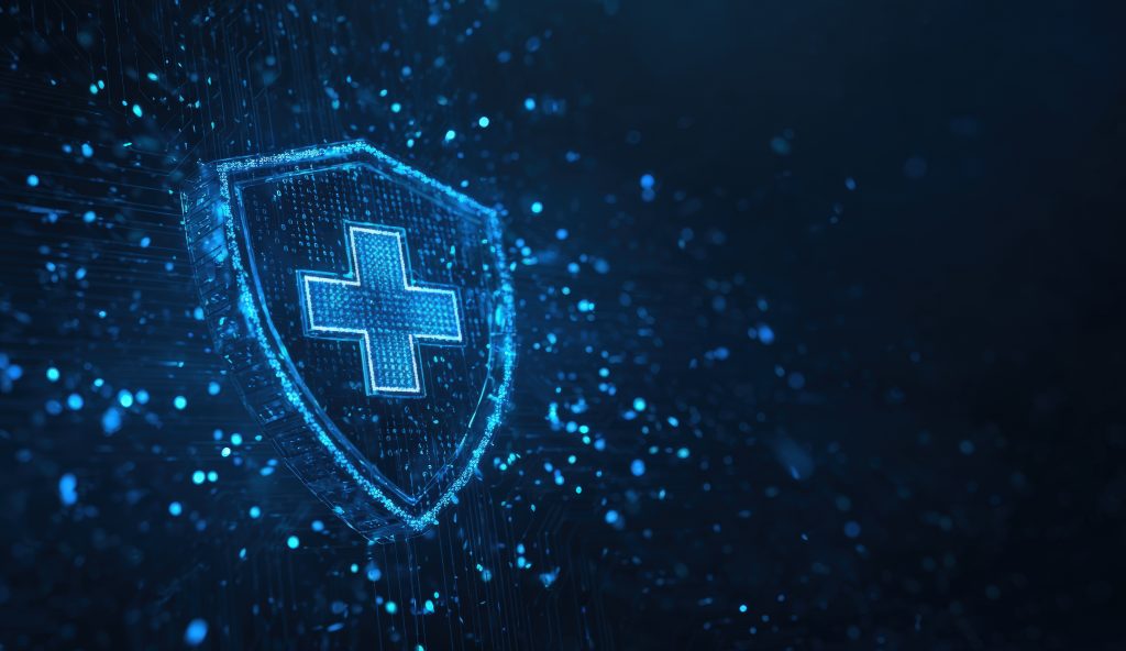 A digital shield with a glowing blue medical cross on it, surrounded by floating particles on a dark blue background.