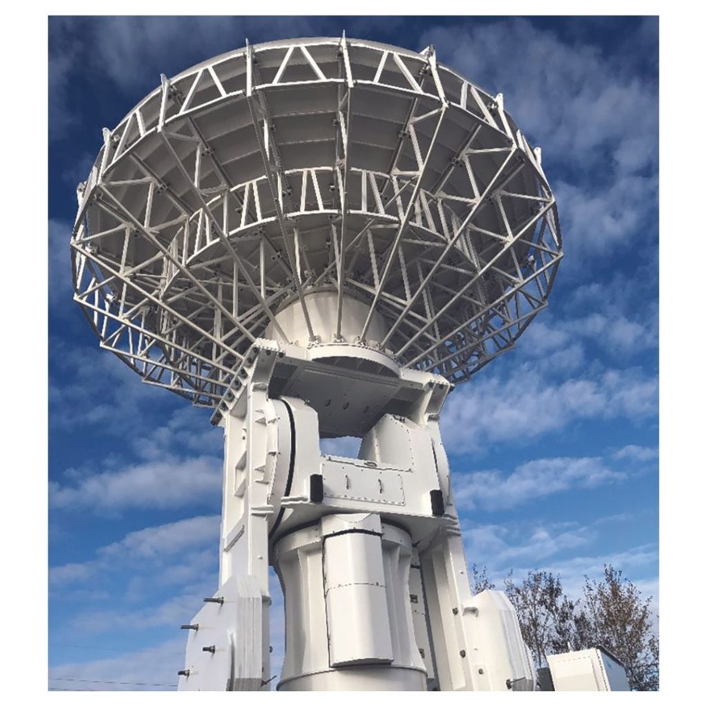 A large white radio telescope is positioned against a backdrop of a blue sky with scattered clouds.