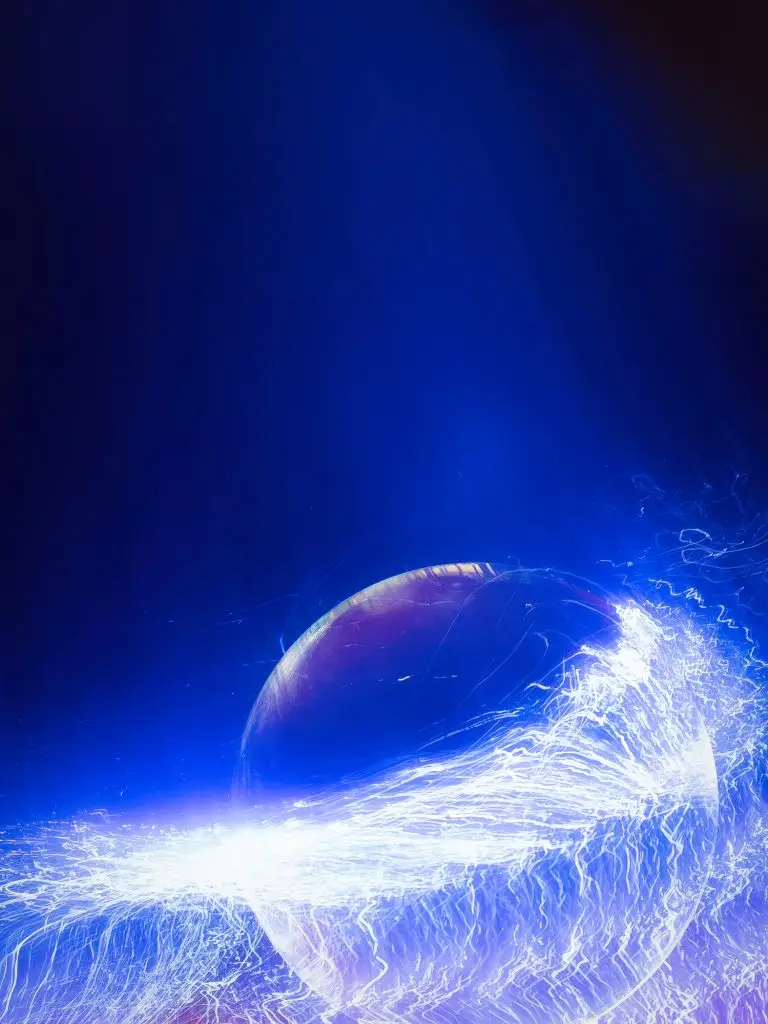 A glowing orb with electric-like streaks of light surrounds its base, set against a dark blue background.