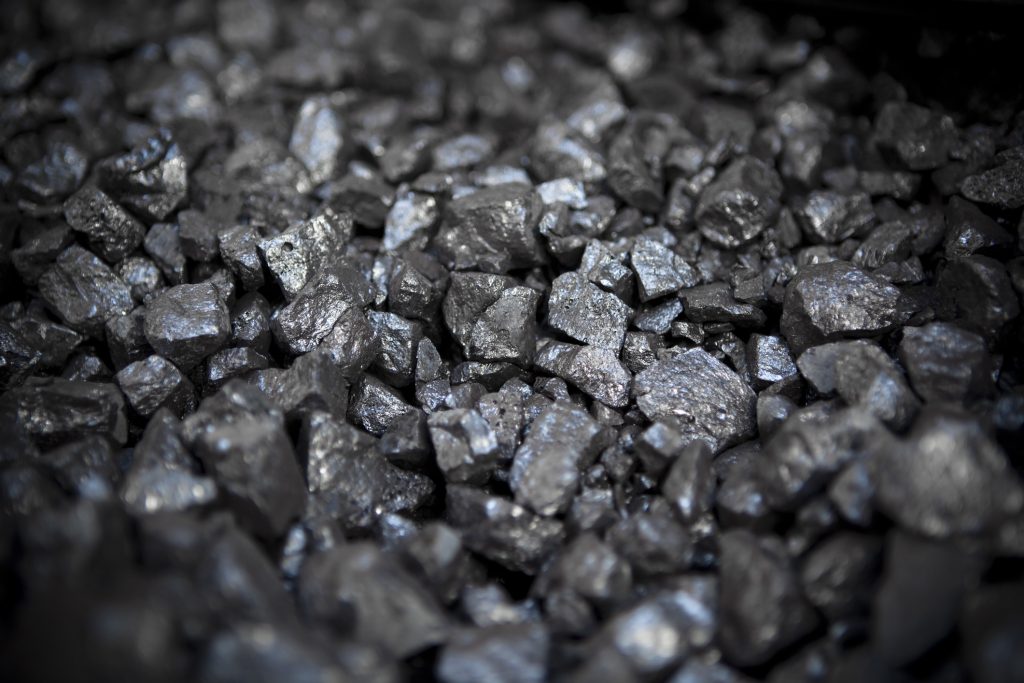 Close-up image of a pile of shiny anthracite coal with a focus on texture and natural metallic sheen.