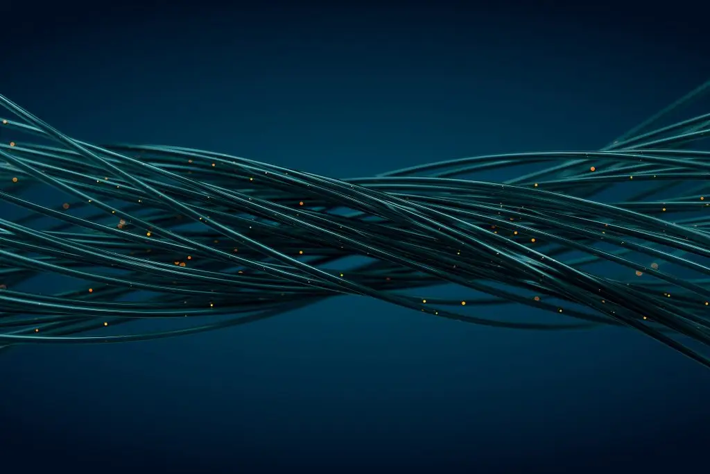 Abstract image of intertwined dark blue cables with small glowing orange lights, symbolizing connectivity or technology, set against a deep blue background.