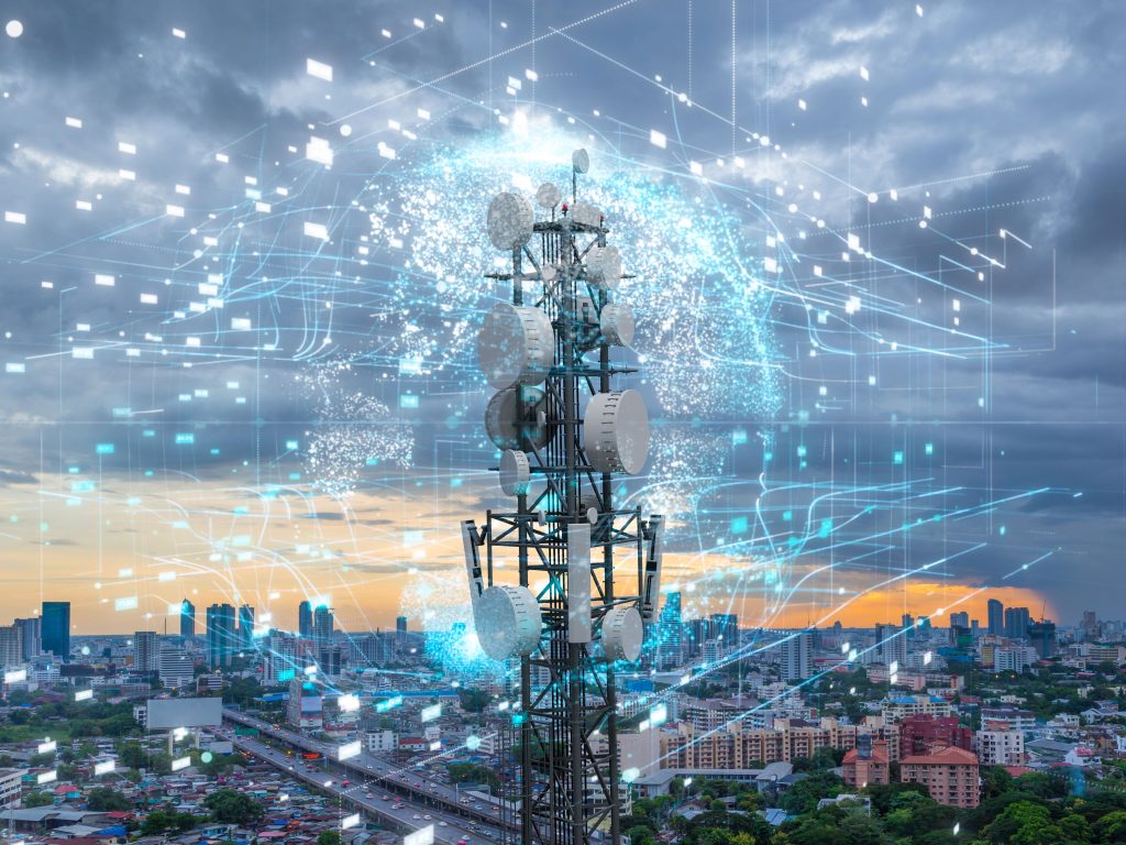 A telecommunications tower with multiple antennas and transmitters, set against an urban cityscape at sunset, overlaid with digital network graphics.