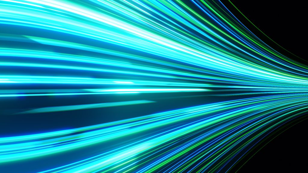An abstract image featuring bright, curved blue and green light streaks against a dark background, creating a sense of motion and speed.