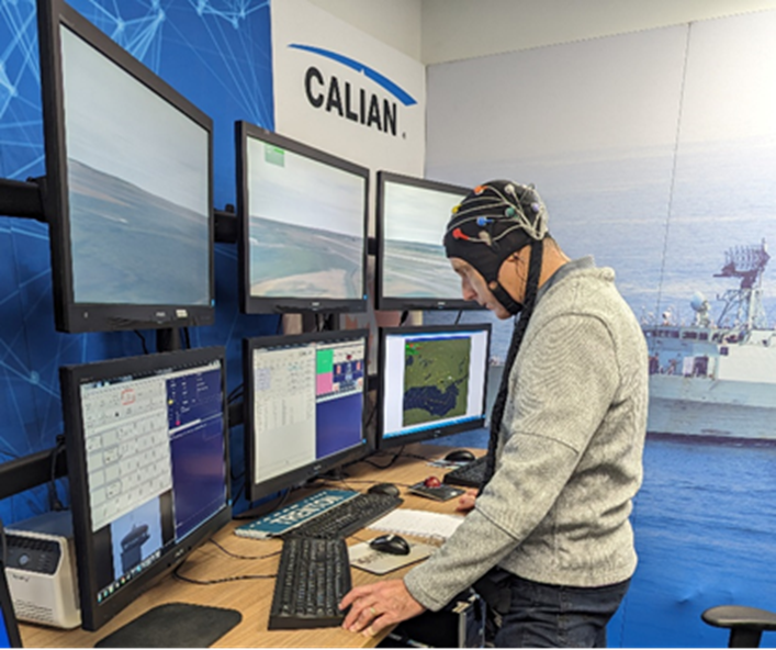 A man working at a desk with several monitors.