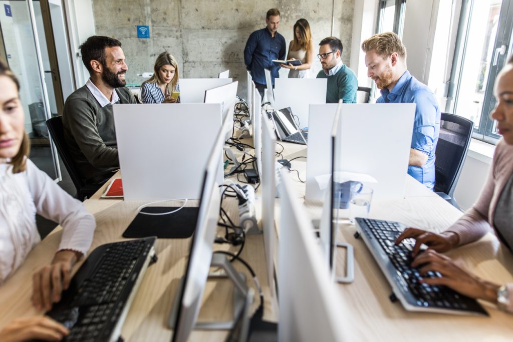 Professionnels travaillant sur des ordinateurs dans un bureau moderne.
