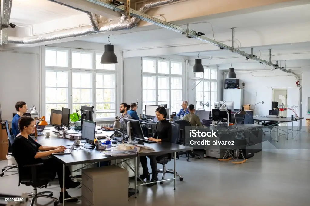 Des employés de bureau s'affairent à leurs tâches dans un espace de travail moderne et lumineux.