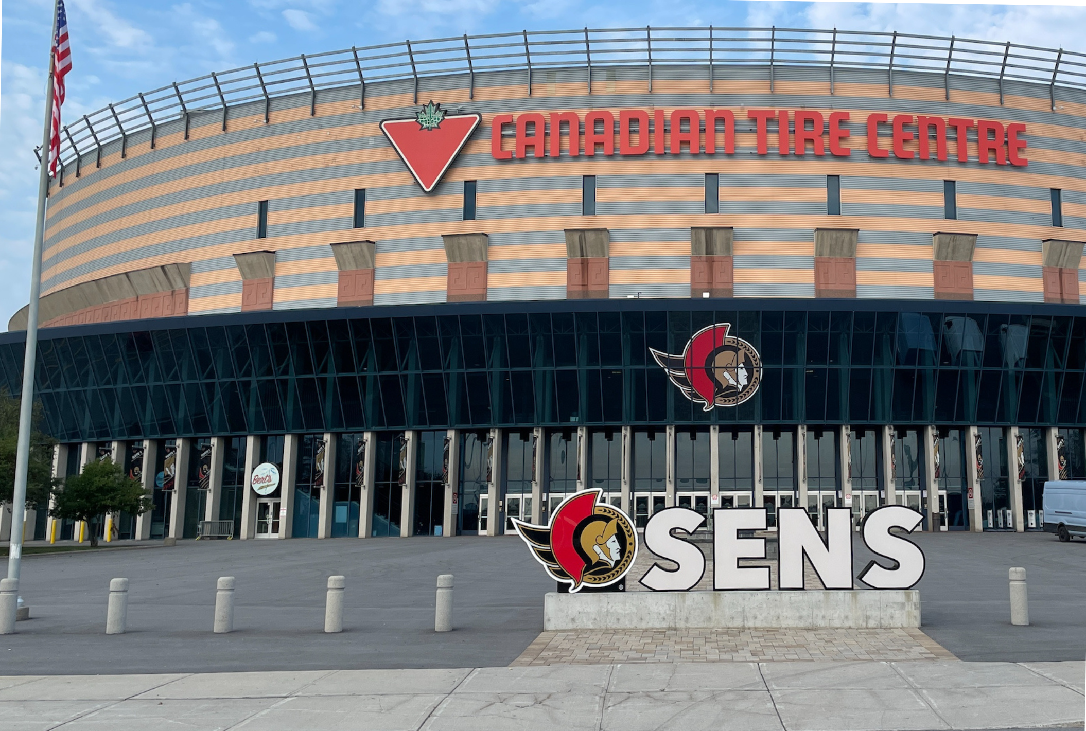 Vue extérieure du Centre Canadian Tire, une arène sportive avec un grand panneau « SENS » et le logo des Sénateurs d'Ottawa à l'avant.